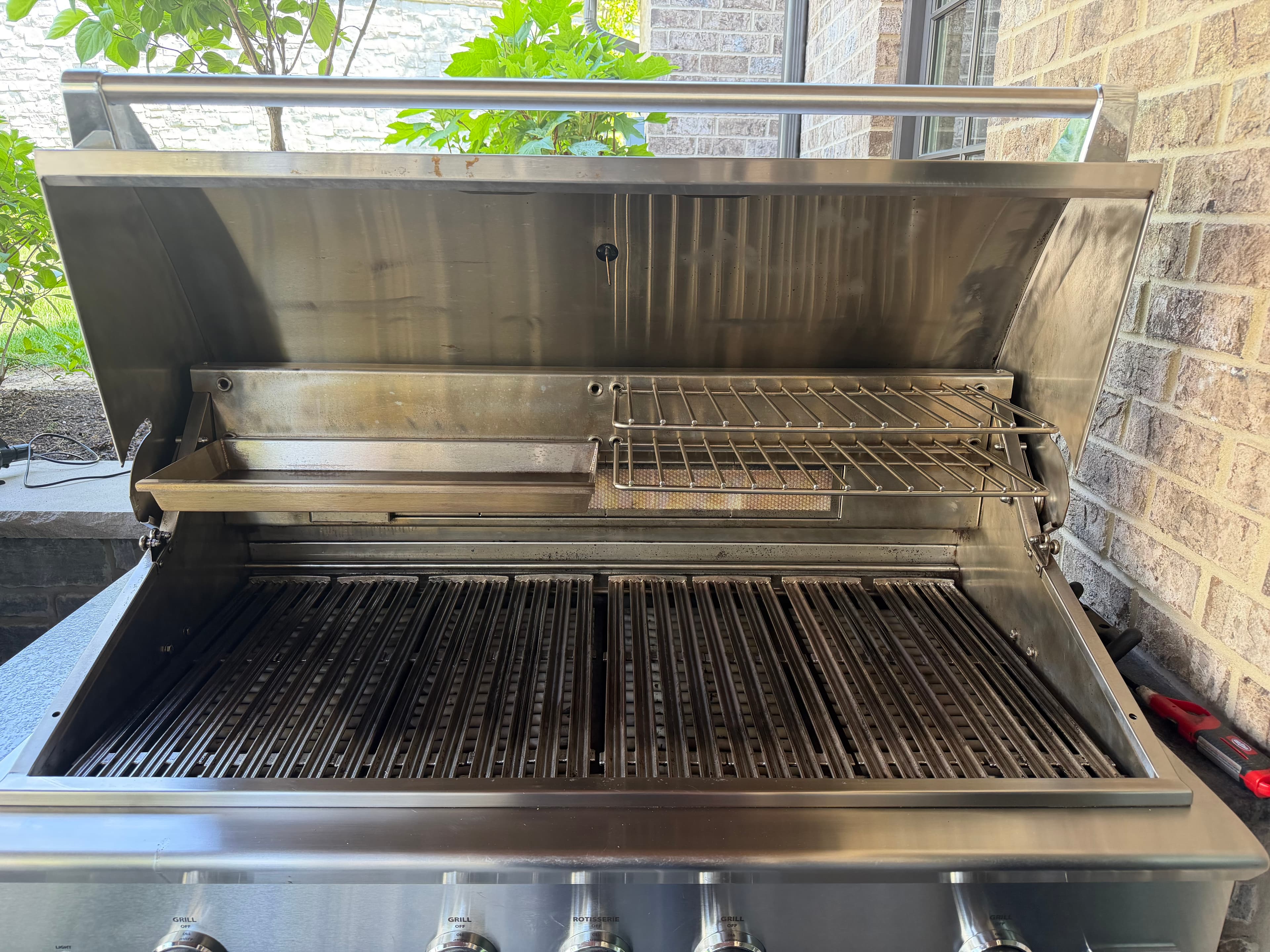 After: the same DCS built-in grill with a polished stainless hood, restored grates, and a spotless cookbox